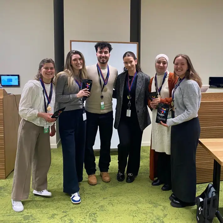 Winning team from Salesforce onboarding treasure hunt posing with medals and prizes at Salesforce Tower Dublin