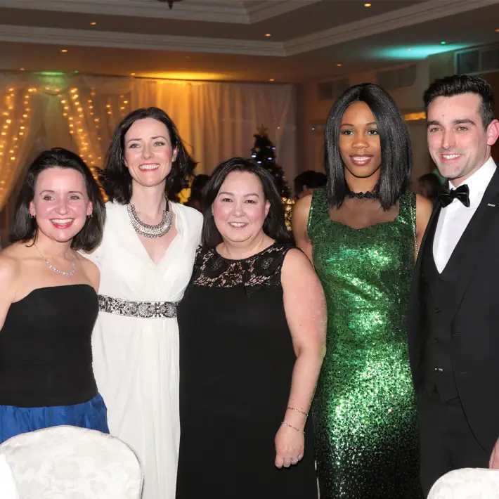 A group of colleagues dressed for a formal dinner during a corporate celebration event, showcasing elegant styling and atmosphere.