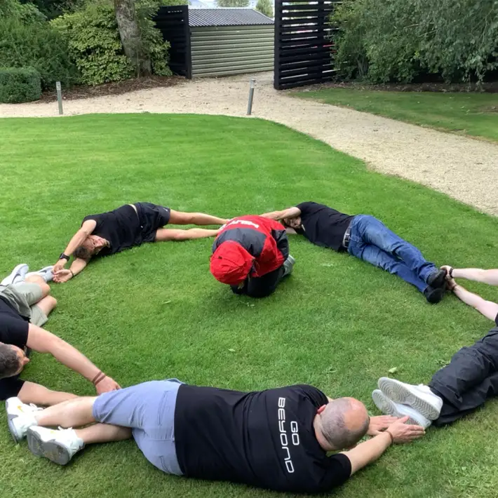 Team members lying on the grass to form planet Jupiter as part of a fun space-themed challenge during Dynamic Events’ Space Survival team building experience in Ireland.