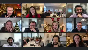Corporate team enjoying a hybrid virtual Christmas party with festive decorations