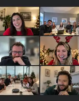 Corporate team enjoying a hybrid virtual Christmas party with festive decorations