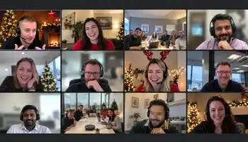Corporate team enjoying a hybrid virtual Christmas party with festive decorations