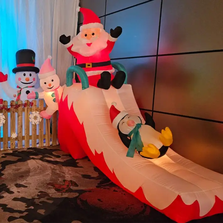 Inflatable Santa on a slide with a penguin and snowmen decorations at a corporate Christmas party in Ireland
