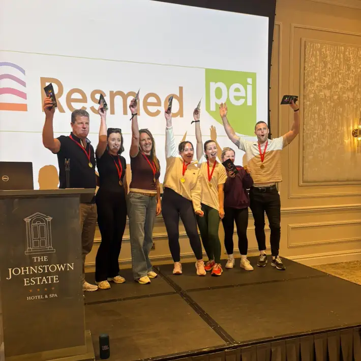 Resmed PEI team celebrating with medals on stage during their corporate team-building day at The Johnstown Estate.