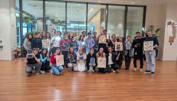 Corporate team holding decorated EcoBuddy bags and solar lights at CSR team building event