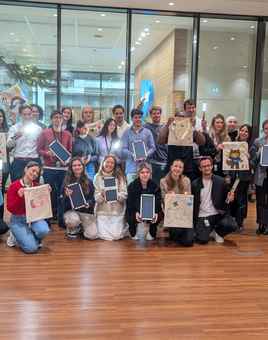 Corporate team holding decorated EcoBuddy bags and solar lights at CSR team building event
