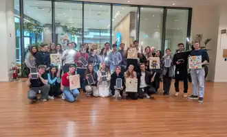 Corporate team holding decorated EcoBuddy bags and solar lights at CSR team building event