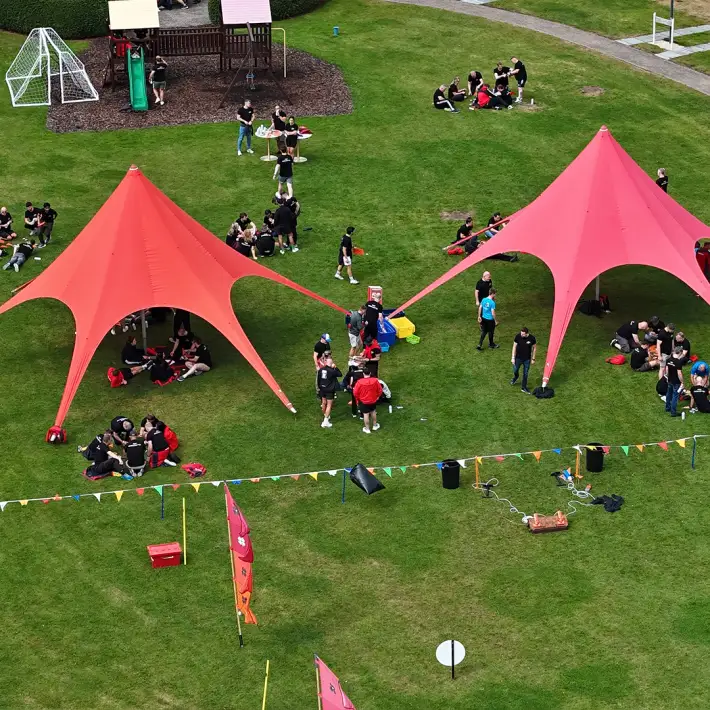 Hilti employees gathered under red marquees for Rocket Challenge team building activity at The Johnstown Estate
