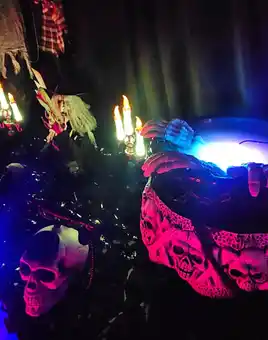 A cauldron made of bones on a creepy table that has uplights in blue and red colours 