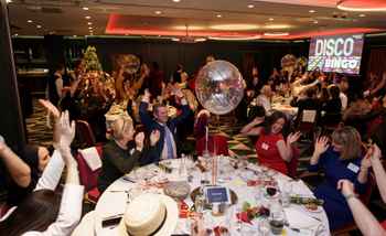Corporate team enjoying a high-energy Disco Bingo event with music, dancing, and laughter at a Christmas party in Ireland.
