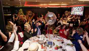 Corporate team enjoying a high-energy Disco Bingo event with music, dancing, and laughter at a Christmas party in Ireland.