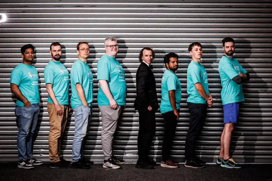 Team in matching shirts with undercover agent during Spy Squad team building challenge