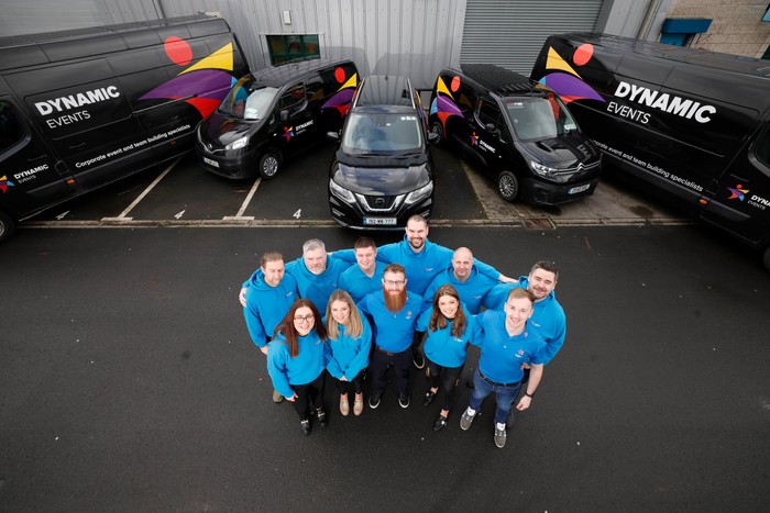 whole team standing in front of dynamic events vans