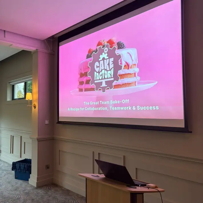Presentation slide for Cake Factory team development activity, introducing MBA students to a business simulation focused on collaboration and process improvement.