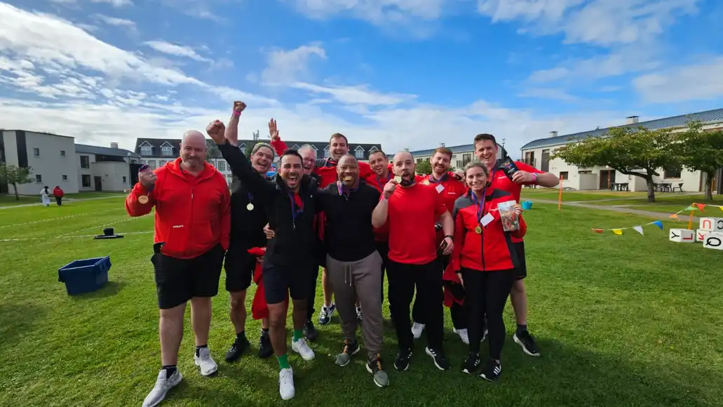 College staff team celebrating success during an outdoor team building challenge in Ireland.