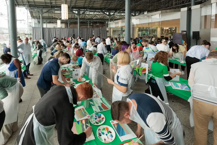 Corporate leadership team building activity in Dublin where executives collaborate on a large group painting workshop to build teamwork and creativity