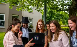 Corporate team using a tablet outdoors during a digital scavenger hunt activity in Ireland
