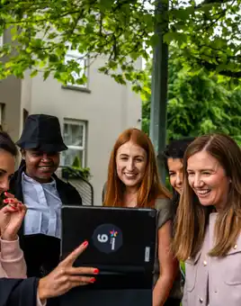 Corporate team using a tablet outdoors during a digital scavenger hunt activity in Ireland