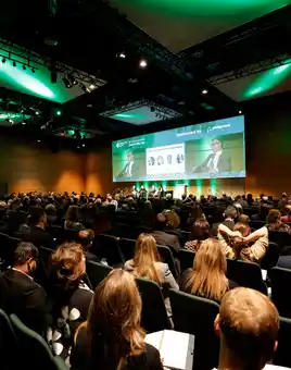Corporate kick-off event with a large audience attending a keynote presentation in a modern conference venue in Ireland.