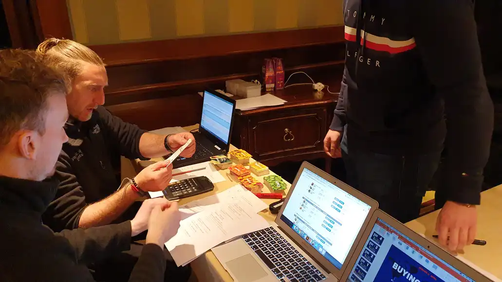 Corporate team engaging in business simulation exercise at trading table event