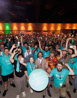 large corporate group taking part in a team building activity at an indoor event