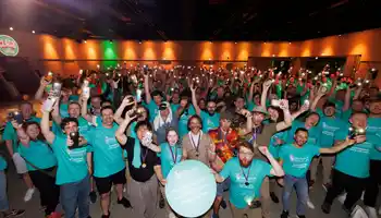 large corporate group taking part in a team building activity at an indoor event