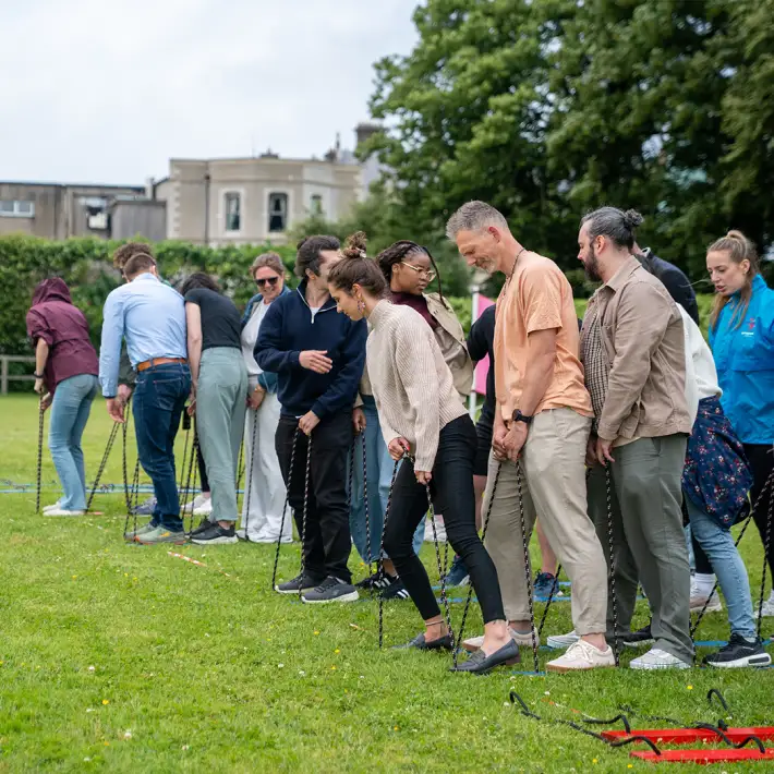 Teams racing on giant team skis during The Challenger outdoor corporate team building activity in Ireland
