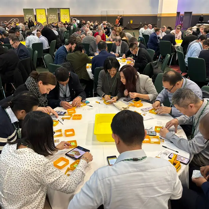 group of participants concentrate on assembling SolarBuddy kits together, highlighting teamwork and engagement.