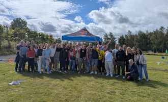 Corporate team building event in Northern Ireland with a large group outdoors under a Dynamic Events tent.