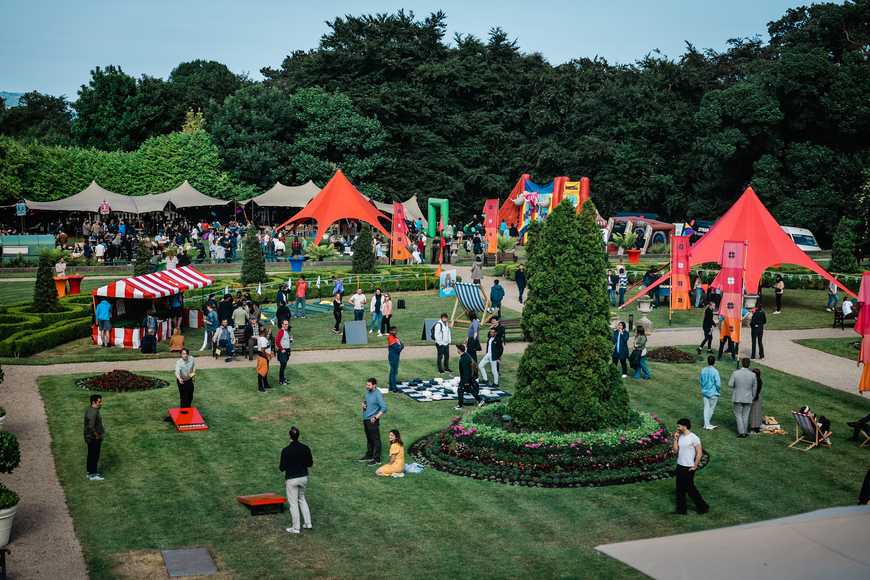 Large corporate summer party with games, food stalls, and entertainment tents at an outdoor venue in Ireland