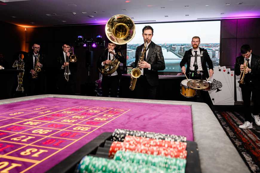 Live brass band performing at corporate casino night event in Sligo with roulette table and casino theme entertainment.