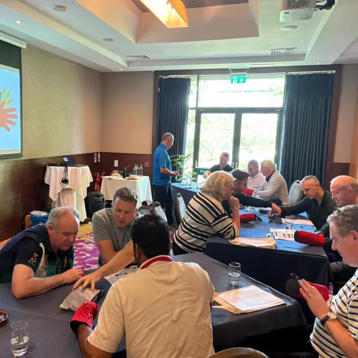 Corporate group in Ireland collaborating on The Hand Project CSR activity, building prosthetic hands in teams as part of a meaningful team building workshop.