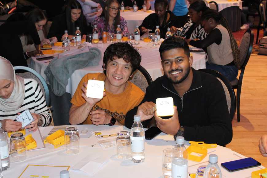 Employees proudly holding assembled SolarBuddy lights at corporate CSR team event