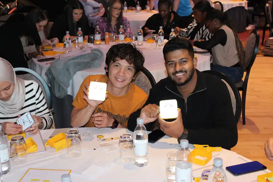 Corporate team building in Ireland with employees assembling SolarBuddy lights during a CSR workshop