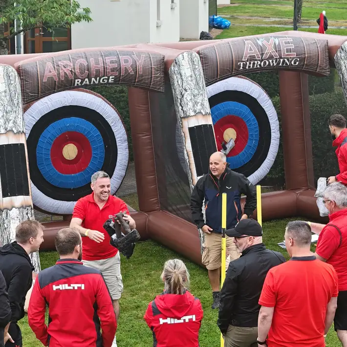 Hilti team taking part in inflatable archery and axe throwing challenge at corporate summer party in Ireland