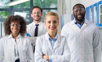 Pharmaceutical team building group of lab professionals smiling together in a collaborative workplace setting