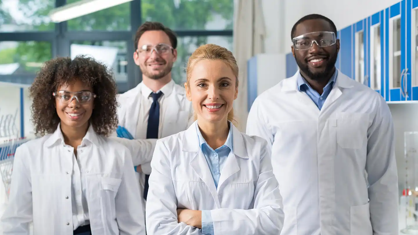 Pharmaceutical team building group of lab professionals smiling together in a collaborative workplace setting