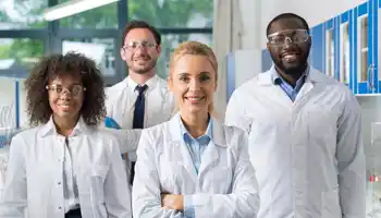 Pharmaceutical team building group of lab professionals smiling together in a collaborative workplace setting