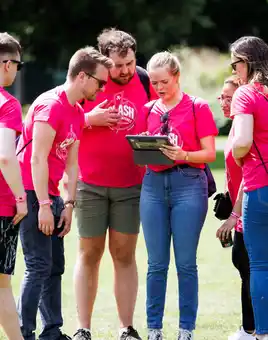 Corporate team using an app during a digital treasure hunt in Dublin smiling and celebrating together outdoors