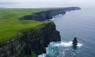 scenic view over green irish fields and mountains